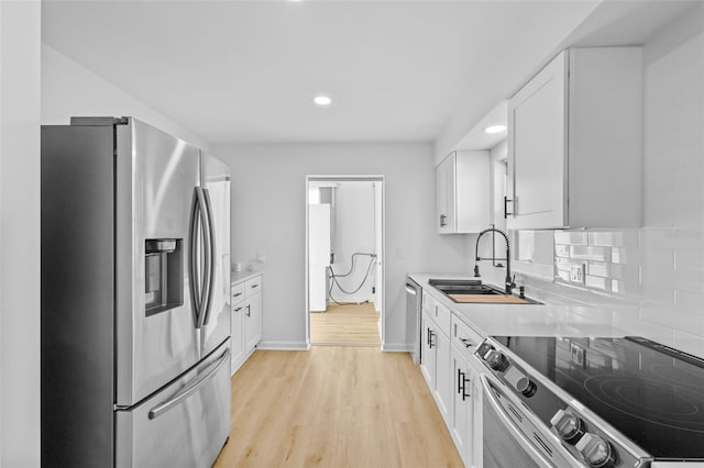 1225 58th St N Unit 204A, Saint Petersburg, FL 33710 - kitchen with stainless steel appliances, a sink, light countertops, white cabinets, and recessed lighting