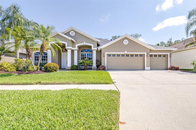 view of front of home featuring a garage, a front lawn, stucco siding, and concrete driveway