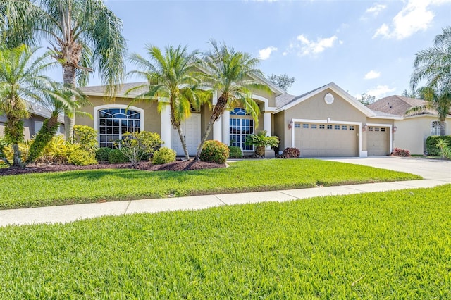 view of front of house featuring stucco siding, concrete driveway, a front yard, and an attached garage