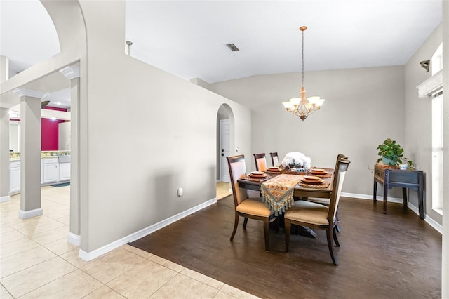 dining room with baseboards, light tile patterned floors, and arched walkways