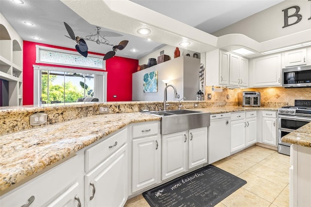 kitchen featuring tasteful backsplash, white cabinetry, stainless steel appliances, and a sink