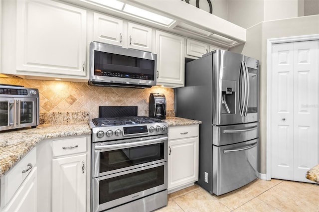 kitchen featuring tasteful backsplash, white cabinets, and appliances with stainless steel finishes
