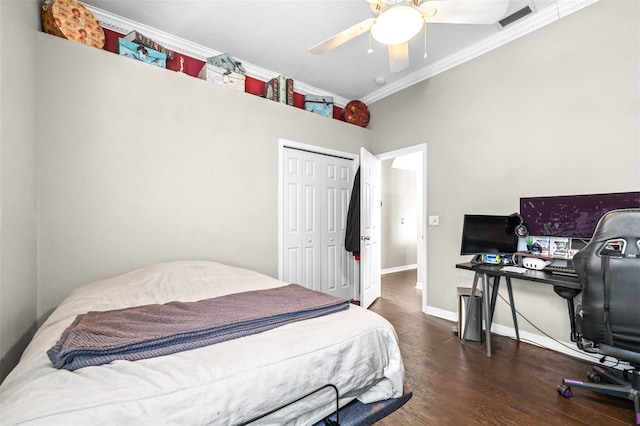 bedroom with visible vents, baseboards, a closet, ornamental molding, and wood finished floors