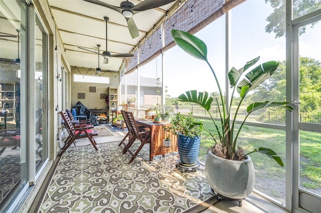 sunroom / solarium featuring a ceiling fan and outdoor dining area