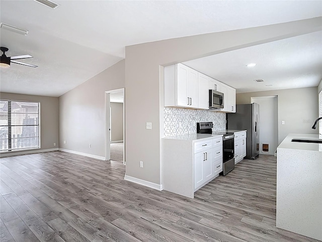 kitchen featuring a sink, light wood-style floors, light countertops, a ceiling fan, and appliances with stainless steel finishes
