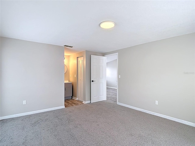 empty room featuring baseboards, carpet, and visible vents