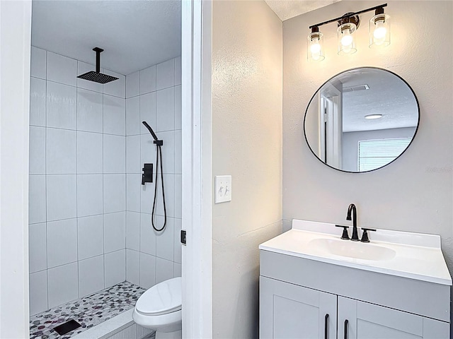 bathroom with vanity, a shower stall, and toilet