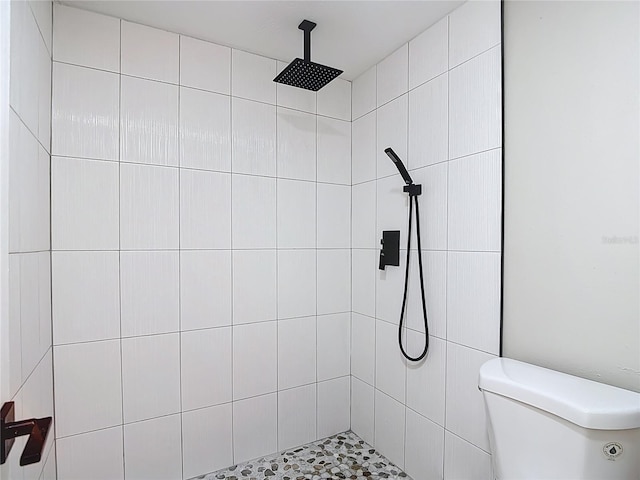 full bathroom featuring toilet and tiled shower