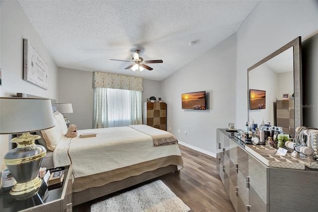 bedroom with baseboards, a textured ceiling, lofted ceiling, and dark wood-style floors