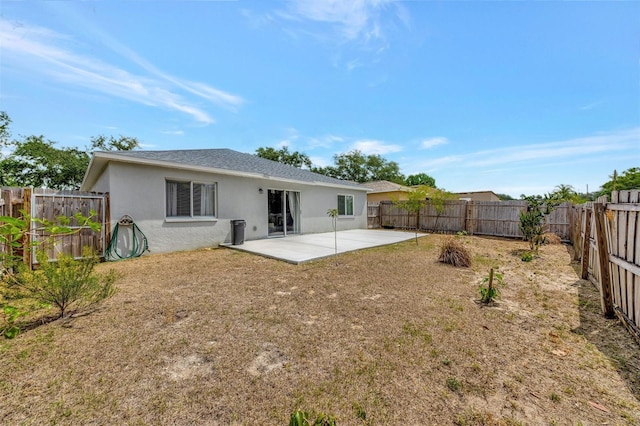 back of property featuring a fenced backyard, stucco siding, a lawn, and a patio area