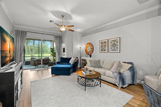 living area featuring crown molding, ceiling fan, light wood-style flooring, and visible vents