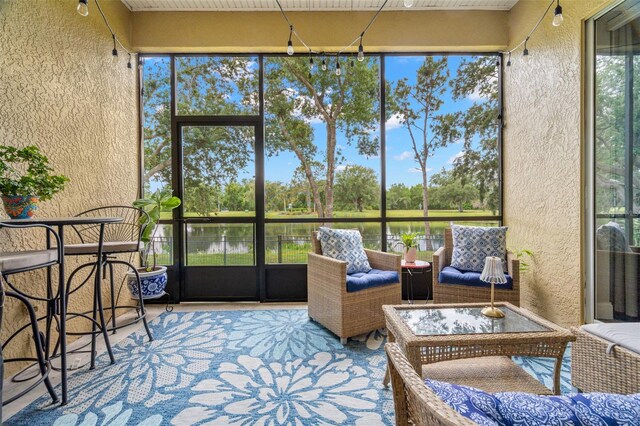 sunroom featuring a water view