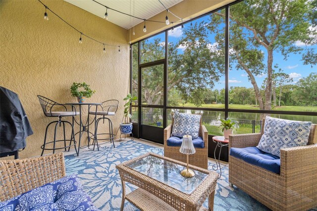 sunroom featuring a water view