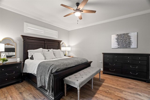 bedroom with ceiling fan, ornamental molding, baseboards, and light wood-style floors