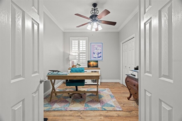 office space with crown molding, baseboards, a ceiling fan, and light wood finished floors