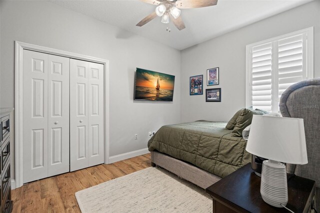 bedroom with a closet, baseboards, a ceiling fan, and light wood-type flooring