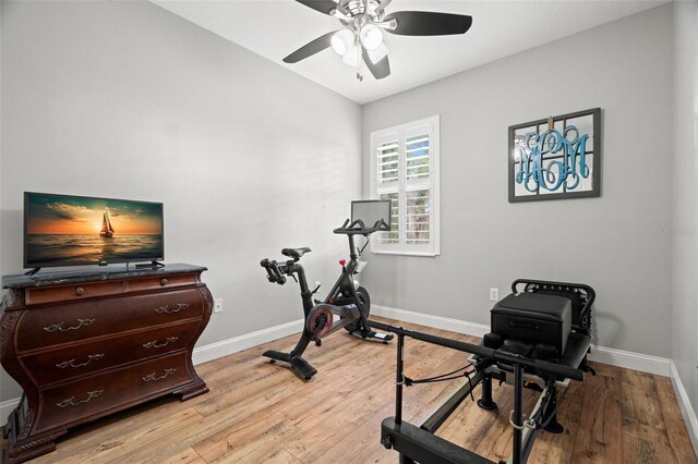workout area with baseboards, light wood-style floors, ceiling fan, and lofted ceiling