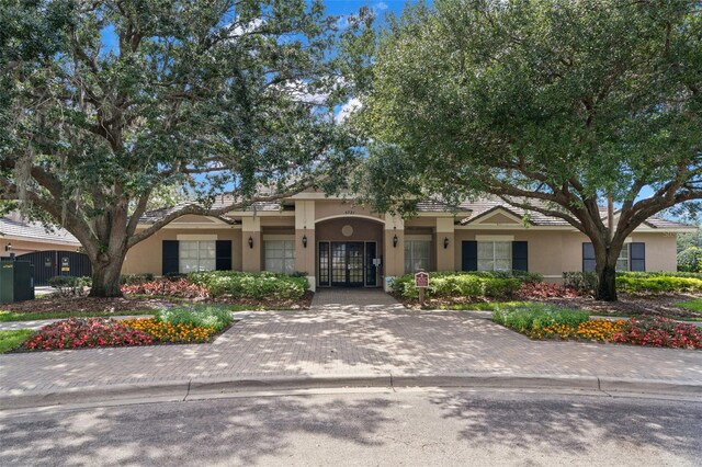 mediterranean / spanish-style house featuring french doors and stucco siding