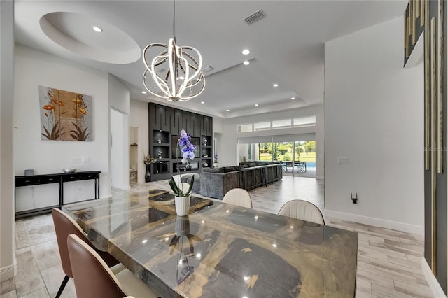 dining room with a raised ceiling, a chandelier, recessed lighting, baseboards, and visible vents