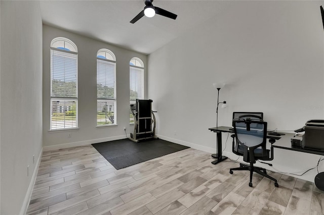 office with baseboards, a ceiling fan, wood finished floors, and a healthy amount of sunlight