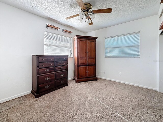 5100 Aragon Way S, Saint Petersburg, FL 33705 - unfurnished bedroom featuring light carpet, a textured ceiling, baseboards, and a ceiling fan