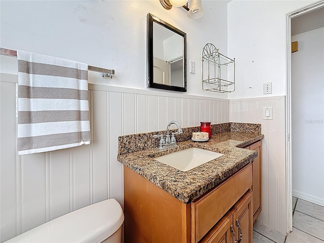 5100 Aragon Way S, Saint Petersburg, FL 33705 - bathroom featuring a wainscoted wall, toilet, a decorative wall, and vanity