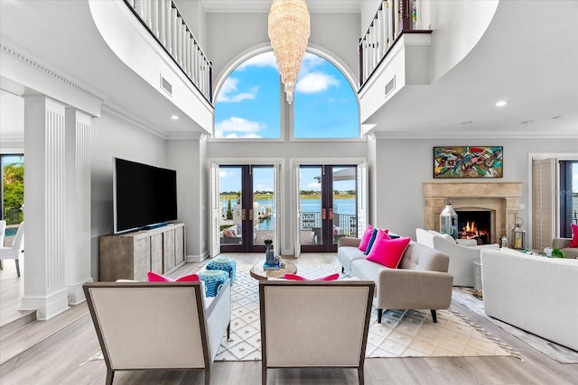 429 St Andrews Dr, Belleair, FL 33756 - living room featuring a towering ceiling, french doors, crown molding, wood finished floors, and a premium fireplace