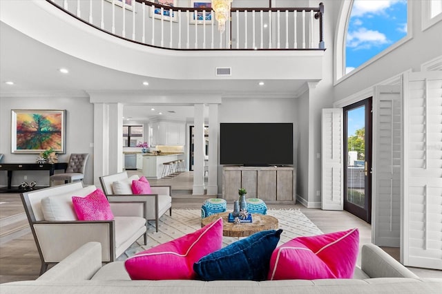 429 St Andrews Dr, Belleair, FL 33756 - living room featuring a high ceiling, ornamental molding, light wood-style floors, recessed lighting, and baseboards