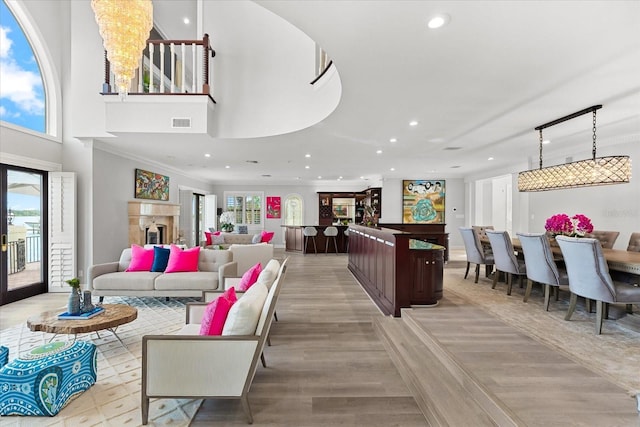 429 St Andrews Dr, Belleair, FL 33756 - living area featuring recessed lighting, light wood finished floors, a towering ceiling, ornamental molding, and bar area