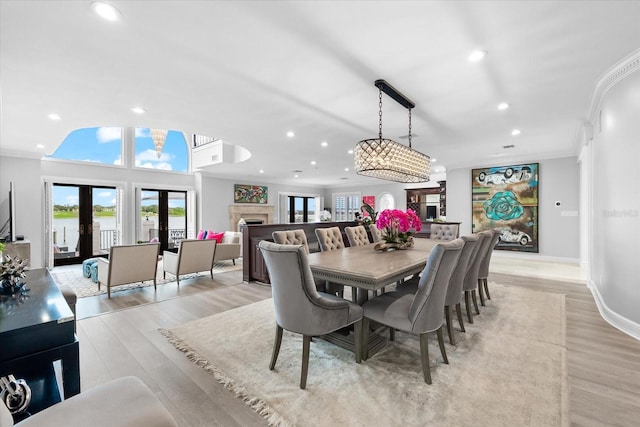 429 St Andrews Dr, Belleair, FL 33756 - dining space with recessed lighting, ornamental molding, light wood-style floors, a fireplace, and french doors