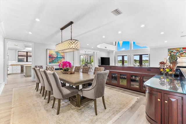 429 St Andrews Dr, Belleair, FL 33756 - dining space featuring crown molding, beverage cooler, recessed lighting, light wood-style floors, and a chandelier