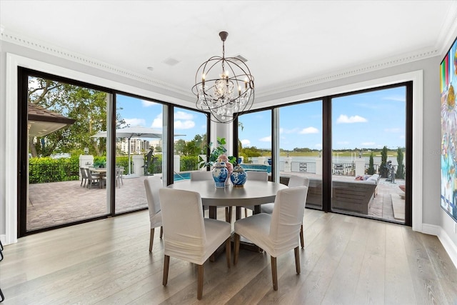 429 St Andrews Dr, Belleair, FL 33756 - dining space with a chandelier, crown molding, light wood-style flooring, a water view, and baseboards