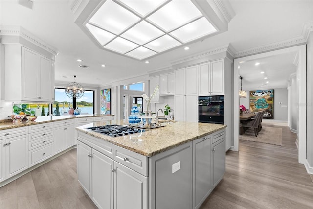 429 St Andrews Dr, Belleair, FL 33756 - kitchen with oven, gas stovetop, recessed lighting, white cabinetry, and crown molding