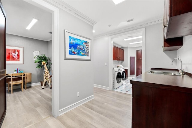 429 St Andrews Dr, Belleair, FL 33756 - hallway with a sink, light wood-style flooring, separate washer and dryer, crown molding, and baseboards