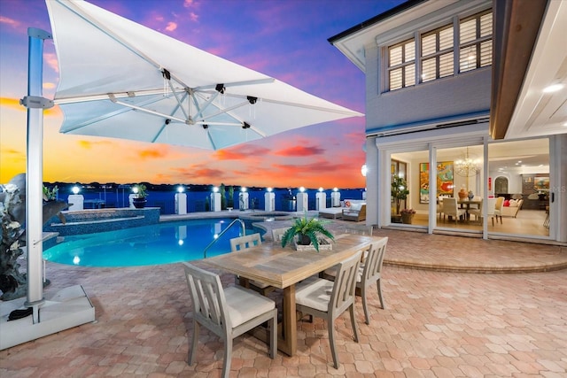 429 St Andrews Dr, Belleair, FL 33756 - pool at dusk featuring a pool with connected hot tub, a patio area, and outdoor dining area