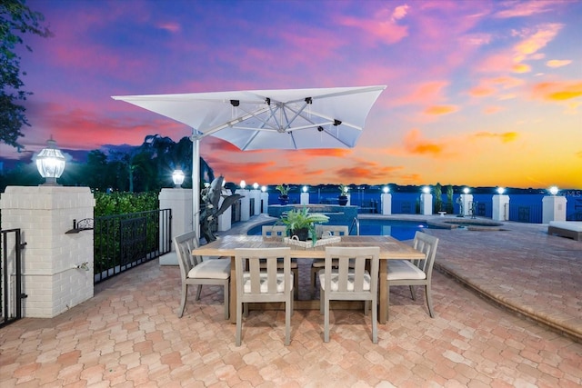 429 St Andrews Dr, Belleair, FL 33756 - patio terrace at dusk featuring outdoor dining space, a patio area, and a pool with connected hot tub
