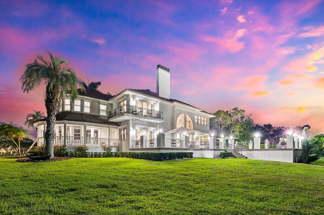 429 St Andrews Dr, Belleair, FL 33756 - rear view of property featuring a balcony, a chimney, a lawn, and french doors