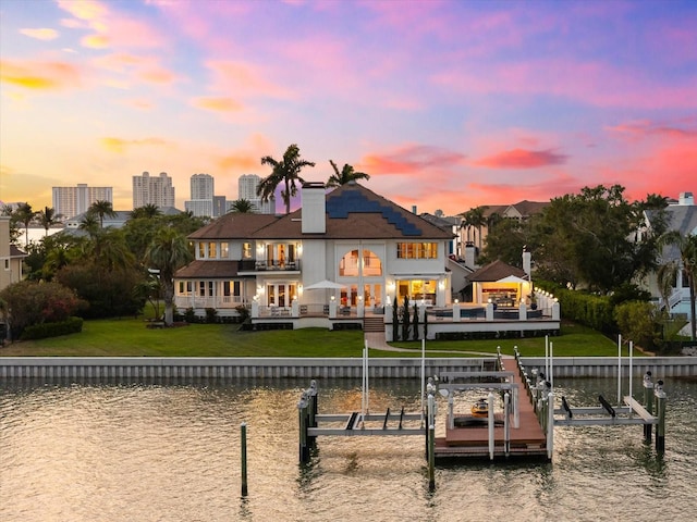 429 St Andrews Dr, Belleair, FL 33756 - back of property featuring boat lift, a balcony, a water view, a lawn, and a chimney