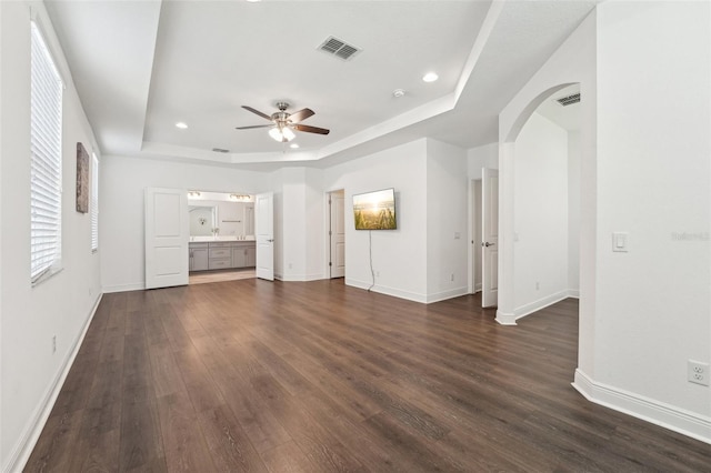 1741 Cherry Walk Rd, Lutz, FL 33558 - unfurnished living room with a raised ceiling, visible vents, baseboards, dark wood finished floors, and a ceiling fan