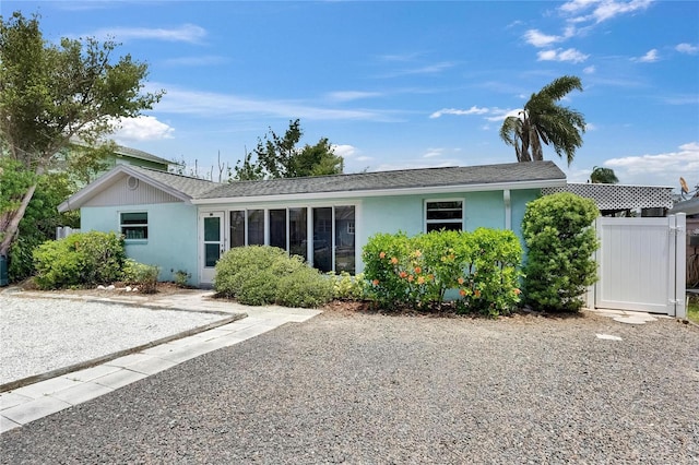 view of front of home featuring fence, roof with shingles, and stucco siding