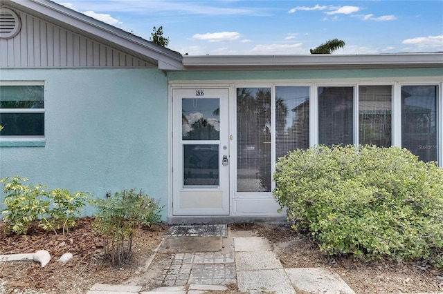 view of exterior entry featuring stucco siding