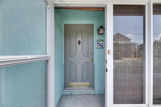 property entrance with stucco siding