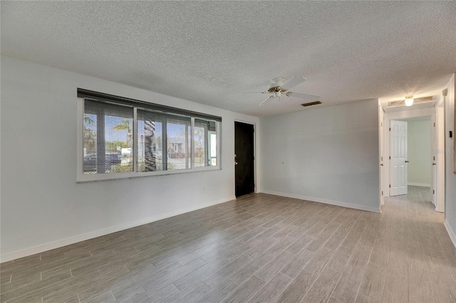 unfurnished room with baseboards, a textured ceiling, ceiling fan, and wood finished floors