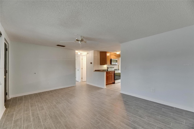 unfurnished living room featuring visible vents, a textured ceiling, light wood finished floors, and ceiling fan