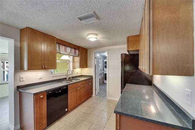 kitchen featuring dark countertops, a sink, baseboards, visible vents, and black appliances