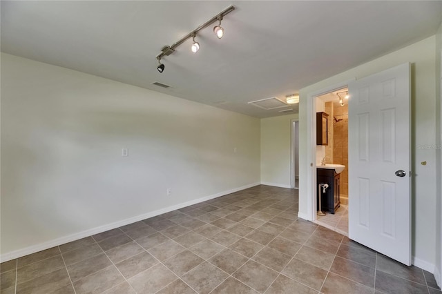 spare room with track lighting, visible vents, baseboards, tile patterned floors, and a sink