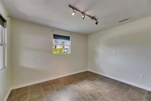 tiled empty room with baseboards, rail lighting, and visible vents