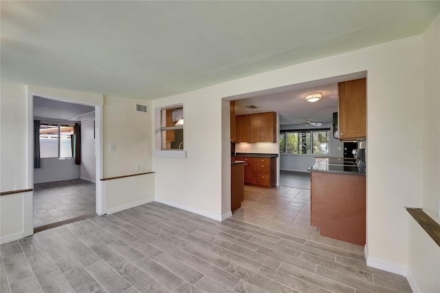 empty room featuring baseboards, light wood-style flooring, and visible vents