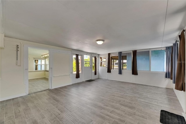 empty room featuring light wood-type flooring and baseboards