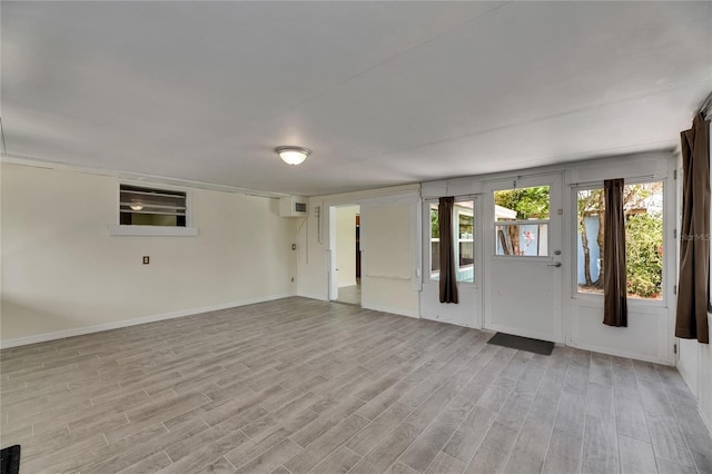spare room with baseboards and light wood-type flooring